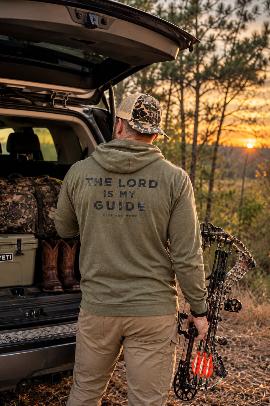 Hunt One More founder in The Lord Is My Guide hoodie with his bow at a Florida trailhead at sunset