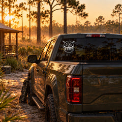 Hunt One More turkey hunting decal on a pickup truck back window in a Florida pine forest at golden hour