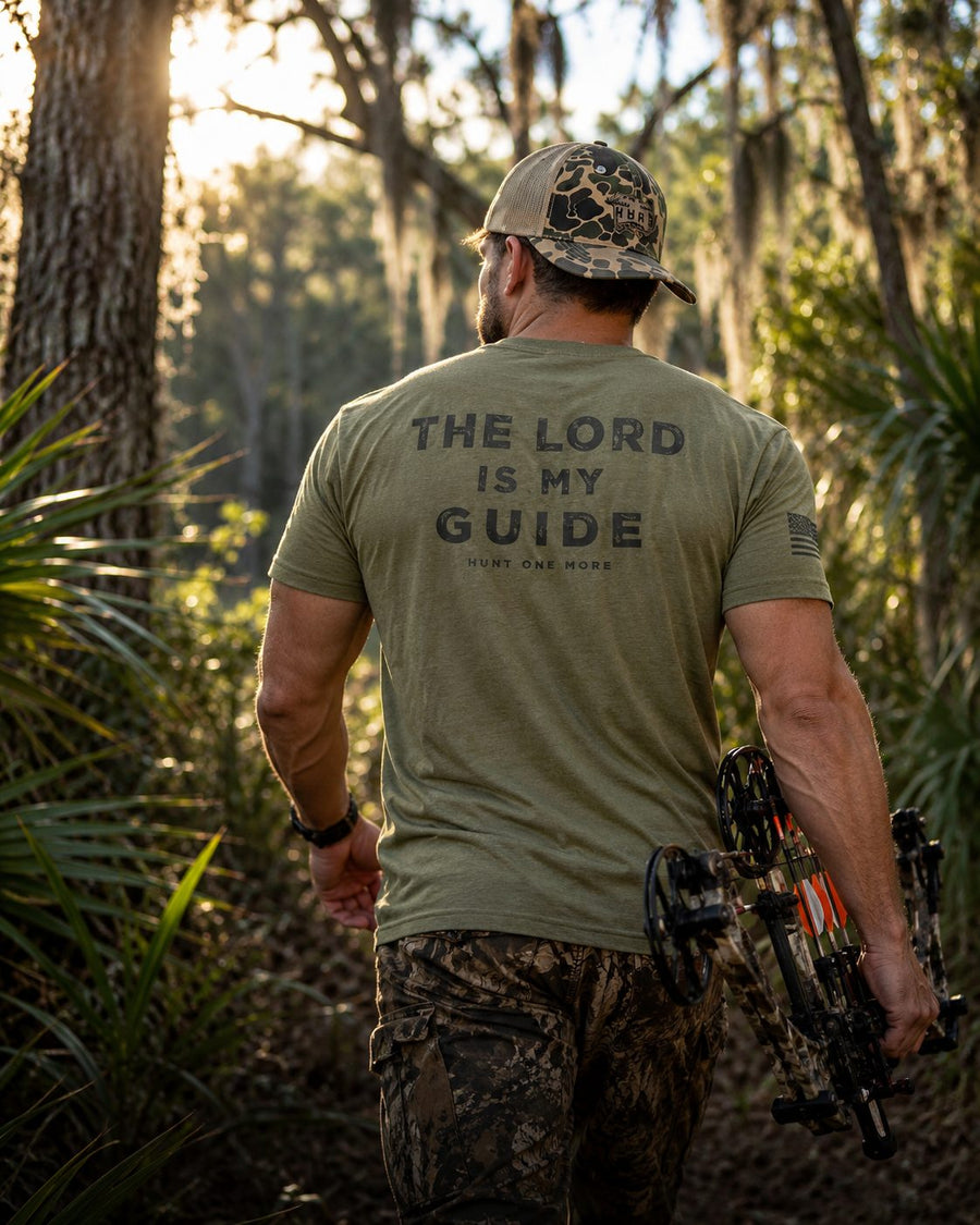 Bowhunter in The Lord Is My Guide hunting t-shirt walking a Florida trail - Hunt One More tees